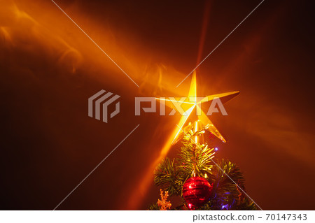 Christmas tree with festive star, orange background with mist 70147343