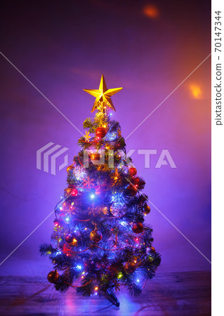 Christmas tree with festive lights, purple background Christmas tree with festive lights, purple background 70147344