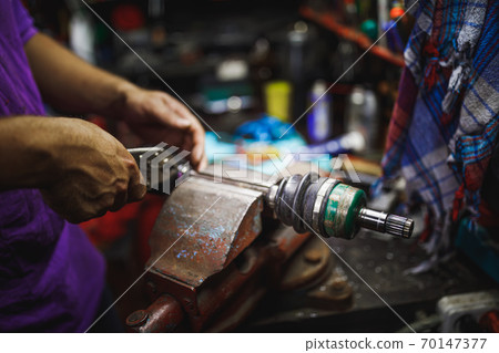 ATV constant-velocity CV joint repair by hands in old garage 70147377