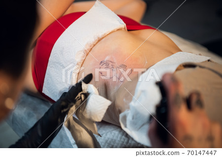 After the work done, the tattoo master processes the client's skin to heal faster After the work done, the tattoo master processes the client's skin to heal faster 70147447