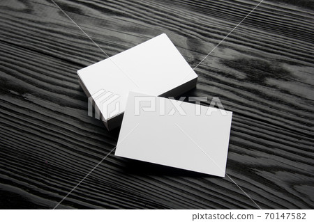 Business card blank on black wooden background. Corporate Stationery, Branding Mock-up. Creative designer desk. Flat lay. Copy space for text 70147582