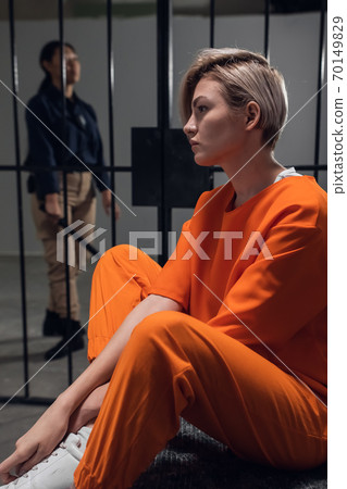 Sad criminal girl in her cell on a bed worries about her fate Sad criminal girl in her cell on a bed worries about her fate 70149829