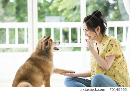 年輕婦女和狗練習他們的手 70149963