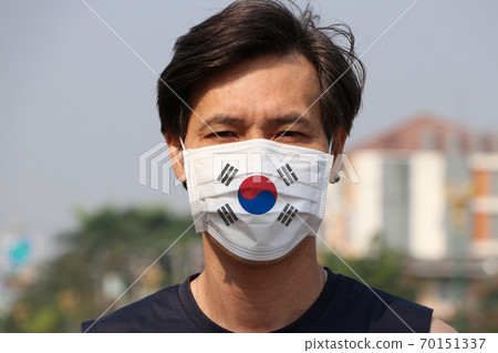 South Korea flag on hygienic mask. Masked Asian man prevent germs. South Korea flag on hygienic mask. Masked Asian man prevent germs. 70151337