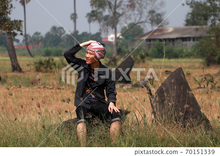 Agriculturist male with loincloth wrapped over the head sitting relax Agriculturist male with loincloth wrapped over the head sitting relax 70151339
