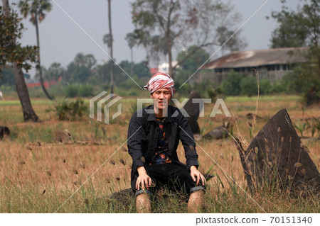 Agriculturist male with loincloth wrapped over the head and sitting relax on nature. Agriculturist male with loincloth wrapped over the head and sitting relax on nature. 70151340