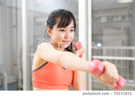 Woman exercising indoors in an apartment building, Muscle training, Girl, Dumbbell, Diet, Sports, Ponytail Woman exercising indoors in an apartment building, Muscle training, Girl, Dumbbell, Diet, Sports, Ponytail 70151653