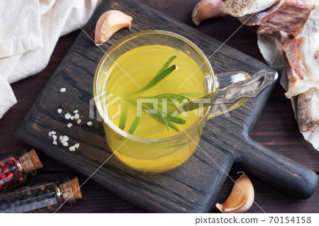 Homemade beef bone and vegetable broth with turmeric seasoning in a glass. Healthy food with collagen and amino acids. Copy space. 70154158