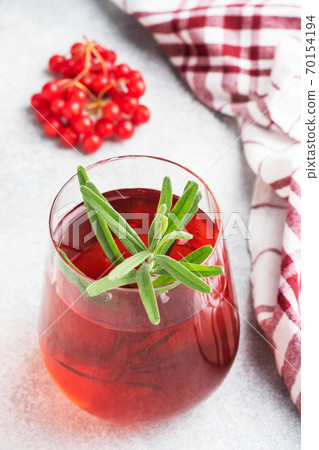 Drink from the berries of red viburnum in glass Cup. Berry compote with vitamin C against the common cold. 70154194