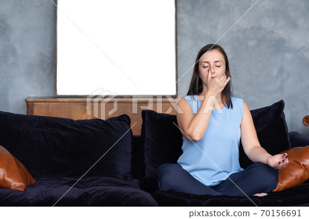 Young caucasian woman working out in living room breathing Pranayama 70156691