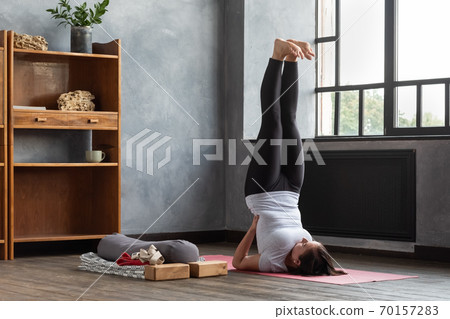 Sporty caucasian woman doing shoulder stand exercise, asana Viparita Karani 70157283