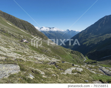 Green mountain valley with Nurnberger Hutte mountain hut, peaks and spring at Stubai hiking trail, Stubai Hohenweg, Summer rocky alpine landscape of Tyrol, Stubai Alps, Austria 70158851