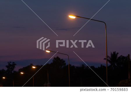 Evening landscape with lighting poles off the road Evening landscape with lighting poles off the road 70159883