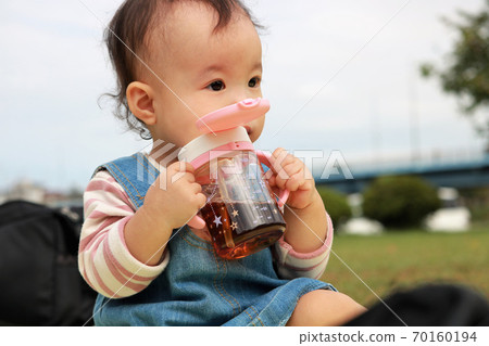 1 year old hydrating in the park 70160194