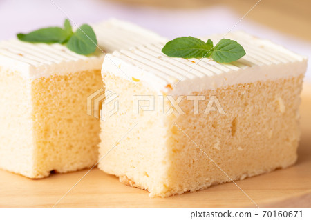Sliced of cheesecake with mint leaves decorated on top. 70160671