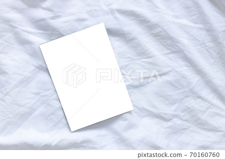 Blank flyer poster mocap on white sheet bed background with copyspace, top view, flat lay 70160760