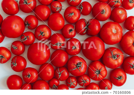 Ripe tomatoes of different size pattern on white background with copy space. Organic vegetables. Ripe tomatoes of different size pattern on white background with copy space. Organic vegetables. 70160806