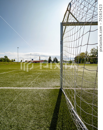 Soccer field in the bright light of summer day Soccer field in the bright light of summer day 70161423