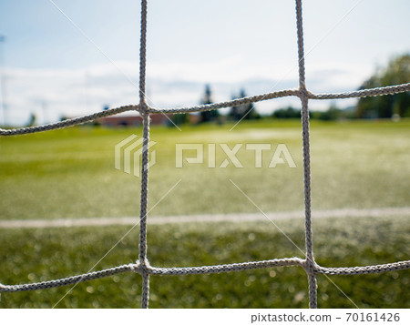 Goalpost net detail with green grass blur in background Goalpost net detail with green grass blur in background 70161426