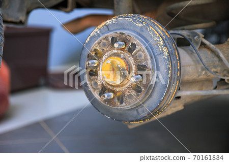 A rear hub of the car after removing a tire and wheel, maintaining a brake and wheel system, car jack-up for change a car wheel, Close-up shot 70161884