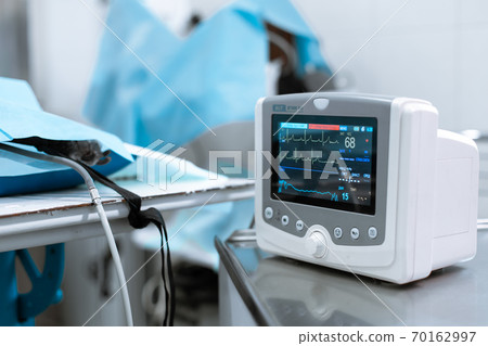 Cardiac monitor at operating table with dog on background. Pet surgery Cardiac monitor at operating table with dog on background. Pet surgery 70162997
