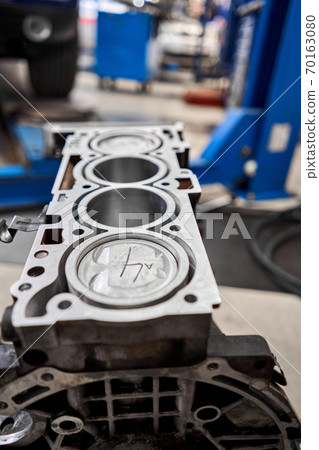 New pistons and cylinder head of engine block vehicle. Motor capital repair. Sixteen valve and four cylinder. Car service concept. The job of a mechanic. Old and new pistons. New pistons and cylinder head of engine block vehicle. Motor capital repair. Sixteen valve and four cylinder. Car service concept. The job of a mechanic. Old and new pistons. 70163080