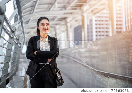 business woman with arms crossed in city 70163088