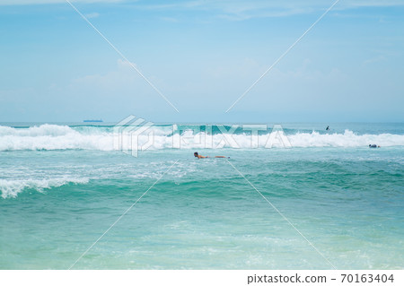 The guy is swimming on the surf board on the ocean. Healthy active lifestyle in summer vocation. 70163404
