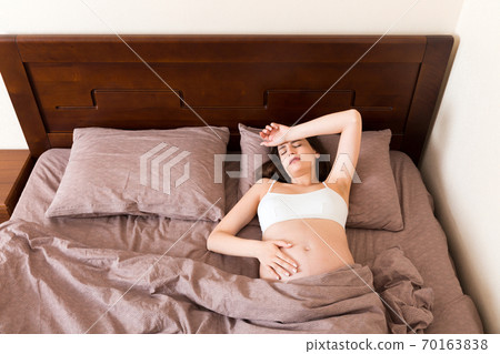 beautiful young pregnant woman lying in bed, top view. the girl suffers from the fact that her husband left her beautiful young pregnant woman lying in bed, top view. the girl suffers from the fact that her husband left her 70163838