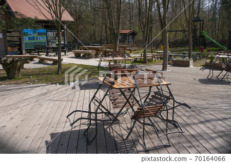 Empty cafe, closed for quarantine. No people. Tables and chairs outside, playground for kids. Empty cafe, closed for quarantine. No people. Tables and chairs outside, playground for kids. 70164066