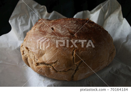Home made sourdough bread on baking paper. Organic food. Whole grain rye flour. 70164184