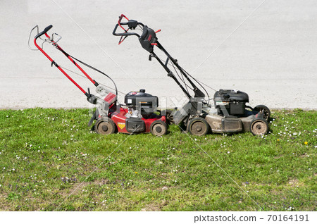 Lawn mowers on green grass, time to cut high grass 70164191