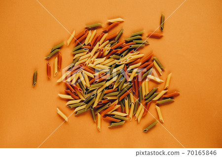 Frame made of colorful green, yellow and red penne pasta naturally coloured with tomato and spinach. 70165846