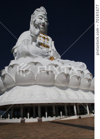 A giant Buddha statue with a Buddhist eye engraved on the palm of the hand in Chiang Rai Watt Phi Raccoon, Thailand A giant Buddha statue with a Buddhist eye engraved on the palm of the hand in Chiang Rai Watt Phi Raccoon, Thailand 70165877