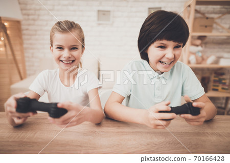 Boy and girl enthusiastically play video games.  70166428