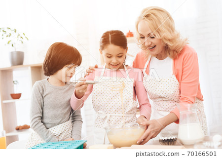 Young granddaughter learning how to cook new dish. Young granddaughter learning how to cook new dish. 70166501
