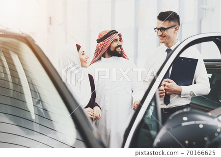 A couple of Arabs came to a car dealership. A couple of Arabs came to a car dealership. 70166625
