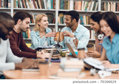 A girl sits next to a mulatto guy and speaks. A girl sits next to a mulatto guy and speaks. 70166629