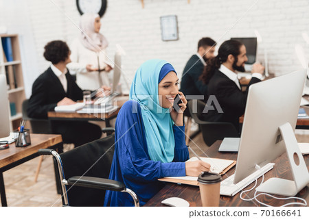 Beautiful arab woman sitting at table and working. 70166641