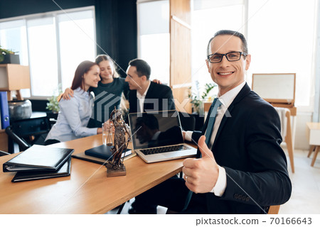 Male lawyer sits at a table and shows thumb up. Male lawyer sits at a table and shows thumb up. 70166643