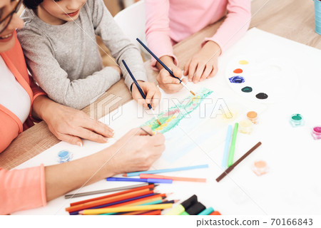 Grandma helps children paint a picture. Grandma helps children paint a picture. 70166843