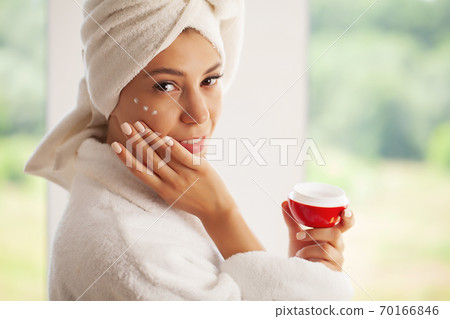 Skin care, beautiful model applying cosmetic cream treatment on her face Skin care, beautiful model applying cosmetic cream treatment on her face 70166846