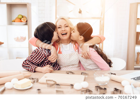 Little grandchildren kiss beautiful grandmother. 70167249