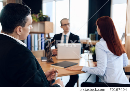 Young serious couple consults, sitting in office. Young serious couple consults, sitting in office. 70167494