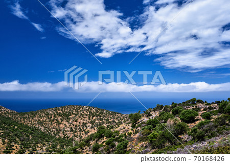 Typical Greek or Cretan landscape, hills and mountains, spring foliage, bush, olive tree, rocky road, path. Akrotiri peninsula, Chania, Crete, Greece Typical Greek or Cretan landscape, hills and mountains, spring foliage, bush, olive tree, rocky road, path. Akrotiri peninsula, Chania, Crete, Greece 70168426