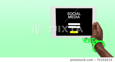 Hand using tablet, device on top view. Addicted, wired with chain to social media on the screen 70168814