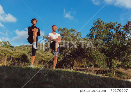 a guy with a girl doing a warm-up in the park a guy with a girl doing a warm-up in the park 70170907
