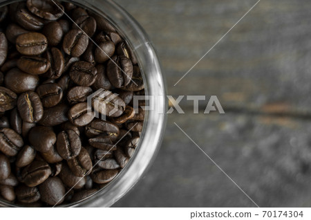 Fresh arabica coffee beans in a little jar on a wooden table. Fresh coffee beans. Fresh arabica coffee beans in a little jar on a wooden table. Fresh coffee beans. 70174304