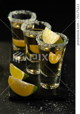 Shots of Mexican Gold Tequila with lime slices and salt. Shots of Mexican Gold Tequila with lime slices and salt. 70175221
