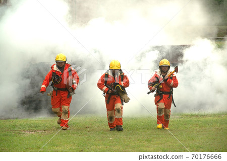 Three firefighters were walking out of the smoke from the fire. Straight ahead. 70176666